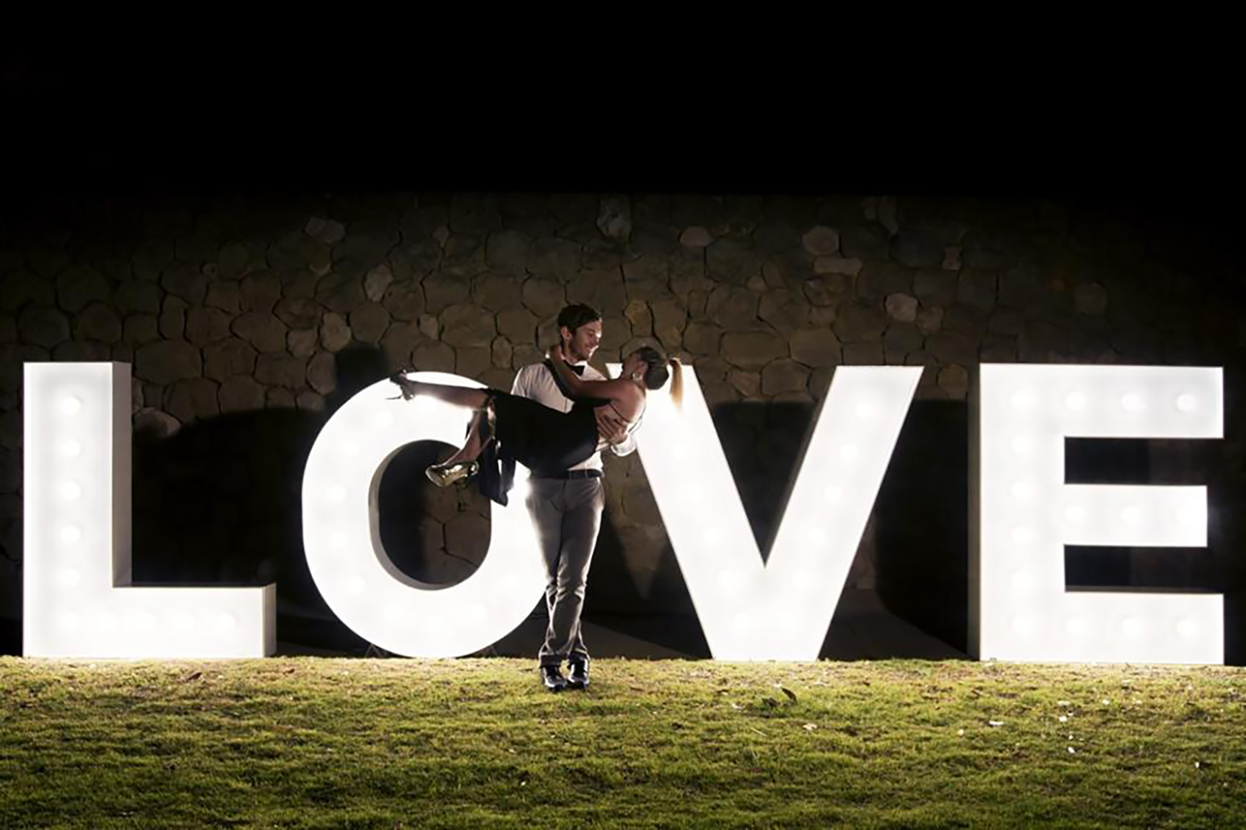 Groom Lifts Bride Photo Light Up Letters For Hire